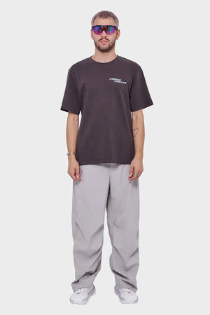 Mężczyzna w okularach sportowych, czarnej koszulce i szarych, szerokich spodniach, styl streetwear