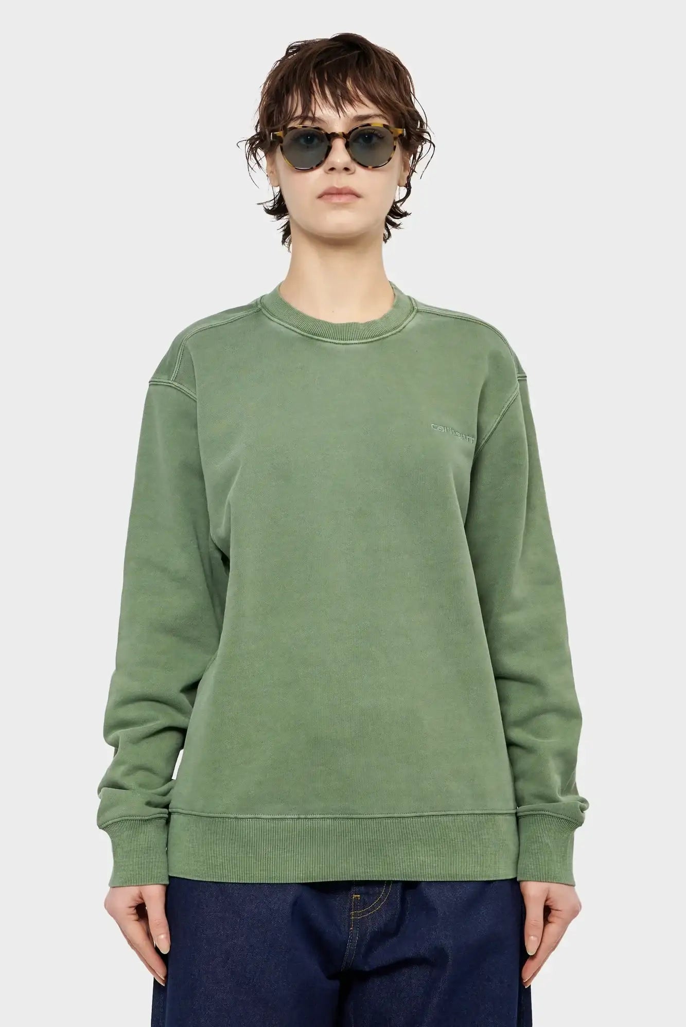 Modelka w zielonej bluzie typu oversize, okulary przeciwsłoneczne, styl streetwear