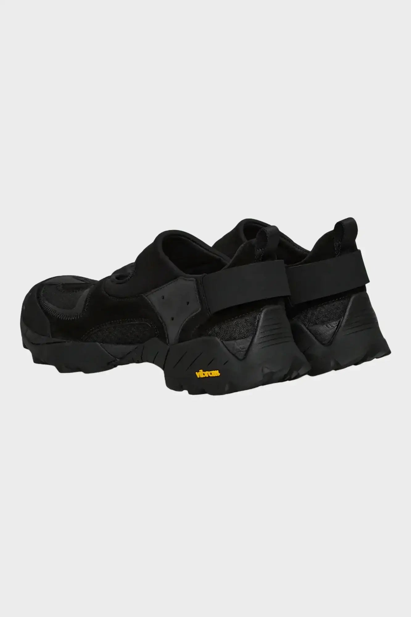 Czarne sportowe buty z grubą podeszwą Vibram, widok z tyłu na białym tle