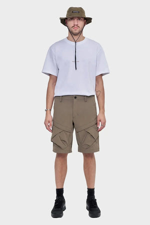 Mężczyzna w białym t-shircie, khaki szortach cargo i oliwkowym kapeluszu typu bucket hat
