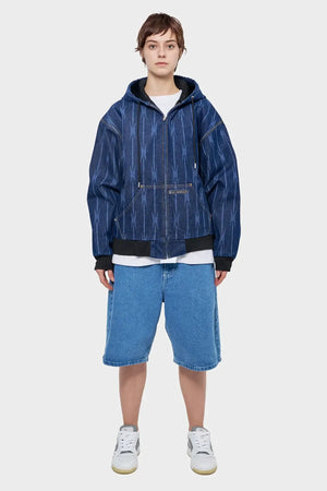 Osoba w dżinsowej bluzie z kapturem i szerokich szortach jeansowych, styl streetwear