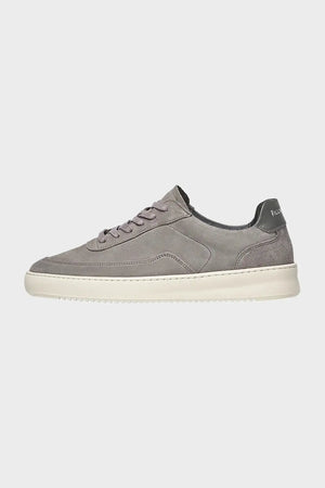 Szary sneakers zamszowy na białej podeszwie, widok z boku, minimalistyczny styl