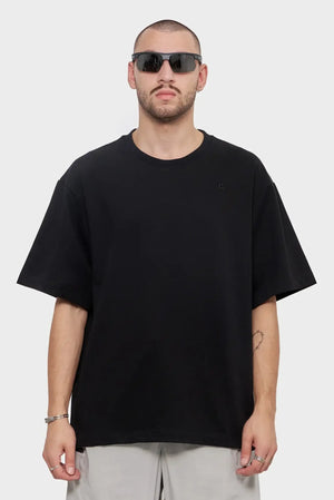 Mężczyzna w czarnej oversize koszulce i okularach przeciwsłonecznych, moda streetwear
