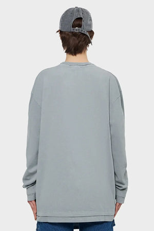 Szara bluza oversize z długim rękawem, model z tyłu, jeansowa czapka, styl streetwear