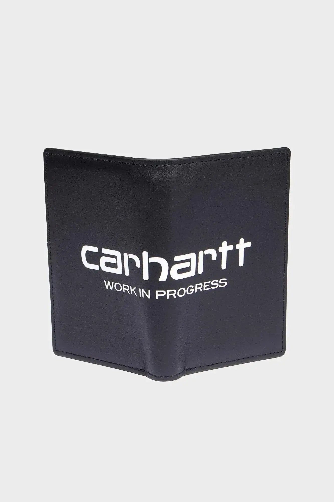 czarny portfel materiałowy z białym napisem carhartt work in progress na jasnym tle