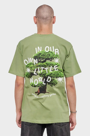 Mężczyzna w zielonej koszulce z grafiką drzewa i napisem na plecach, moda streetwear