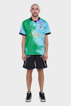 Mężczyzna w zielono-niebieskiej koszulce Rave i czarnych szortach sportowych, styl streetwear