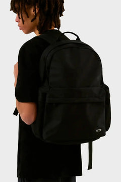 Czarny plecak Arte Antwerp na plecach osoby, minimalistyczny styl, odzież streetwear