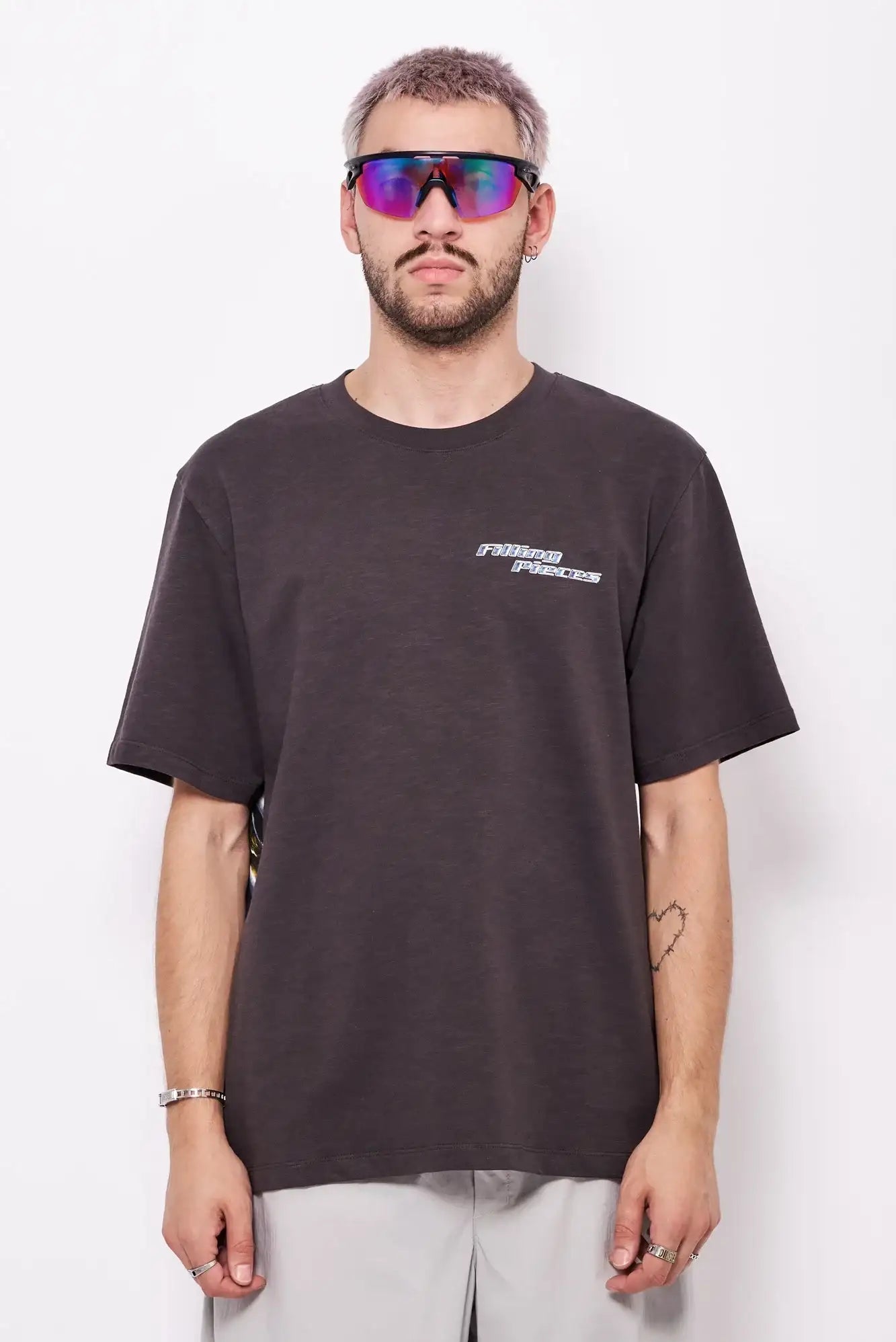 Mężczyzna w czarnej koszulce z napisem, okulary sportowe, modna stylizacja streetwear