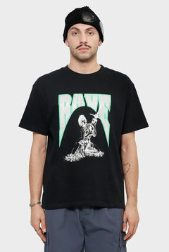 Mężczyzna w czarnej koszulce z napisem RAVE i grafiką, czarna czapka, styl streetwear.