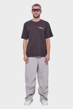 Mężczyzna w okularach sportowych, czarnej koszulce i szarych, szerokich spodniach, styl streetwear