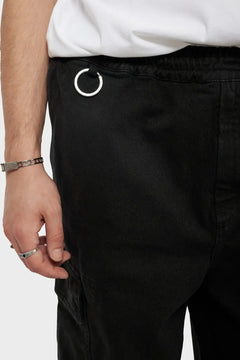 Czarne spodnie z pierścieniem metalowym, detal w pasie, styl streetwear, męska biżuteria