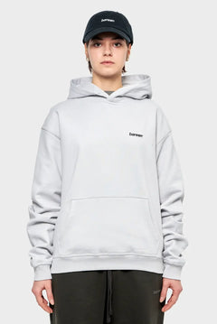 Modelka w jasnej, oversize bluzy z kapturem i czapce z daszkiem, logo bareen, moda streetwear