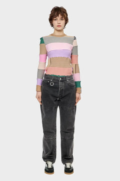 Modelka w kolorowym swetrze w paski i czarnych jeansach, styl streetwear, moda młodzieżowa.