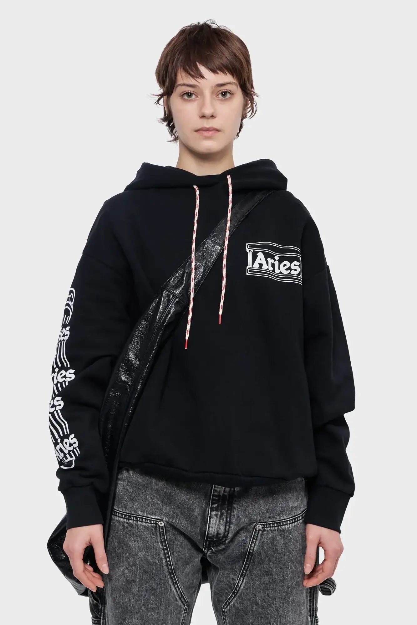 Czarna bluza z kapturem Aries, nadruk na rękawie i piersi, jeansy, modny miejski styl