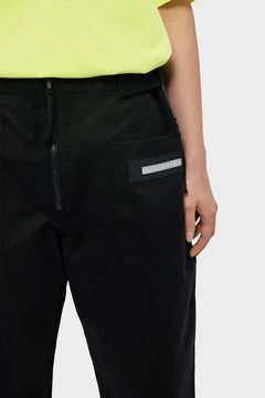 Czarne spodnie cargo Aries, kieszeń z logo, żółty t-shirt, styl streetwear