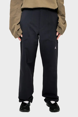 Czarne spodnie streetwear, luźny krój, sportowe buty, beżowa bluza, styl casual