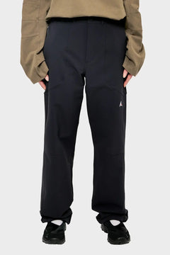 Czarne spodnie streetwear, luźny krój, sportowe buty, beżowa bluza, styl casual