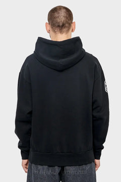 Mężczyzna w czarnej bluzie z kapturem, tył, minimalistyczny styl streetwear