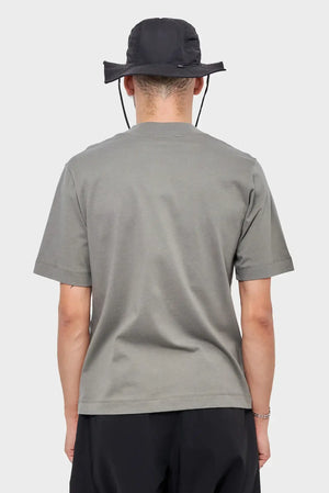 Mężczyzna w szarej koszulce i czarnym kapeluszu, widok od tyłu, moda streetwear
