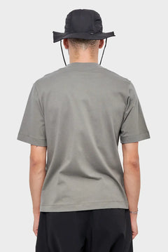 Mężczyzna w szarej koszulce i czarnym kapeluszu, widok od tyłu, moda streetwear