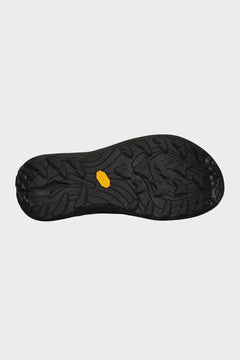 Czarna podeszwa buta outdoor z żółtym logo Vibram, widok od spodu, wzór antypoślizgowy