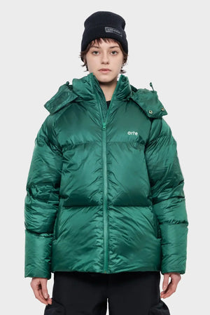 Osoba w zielonej, pikowanej kurtce zimowej z napisem 'arte', czarna czapka, styl streetwear