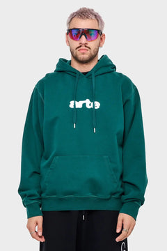 Mężczyzna w zielonej bluzie z kapturem arte, sportowe okulary, moda streetwear