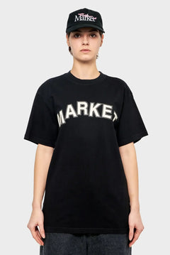Osoba w czarnej koszulce z napisem MARKET i czapce z daszkiem, styl streetwear