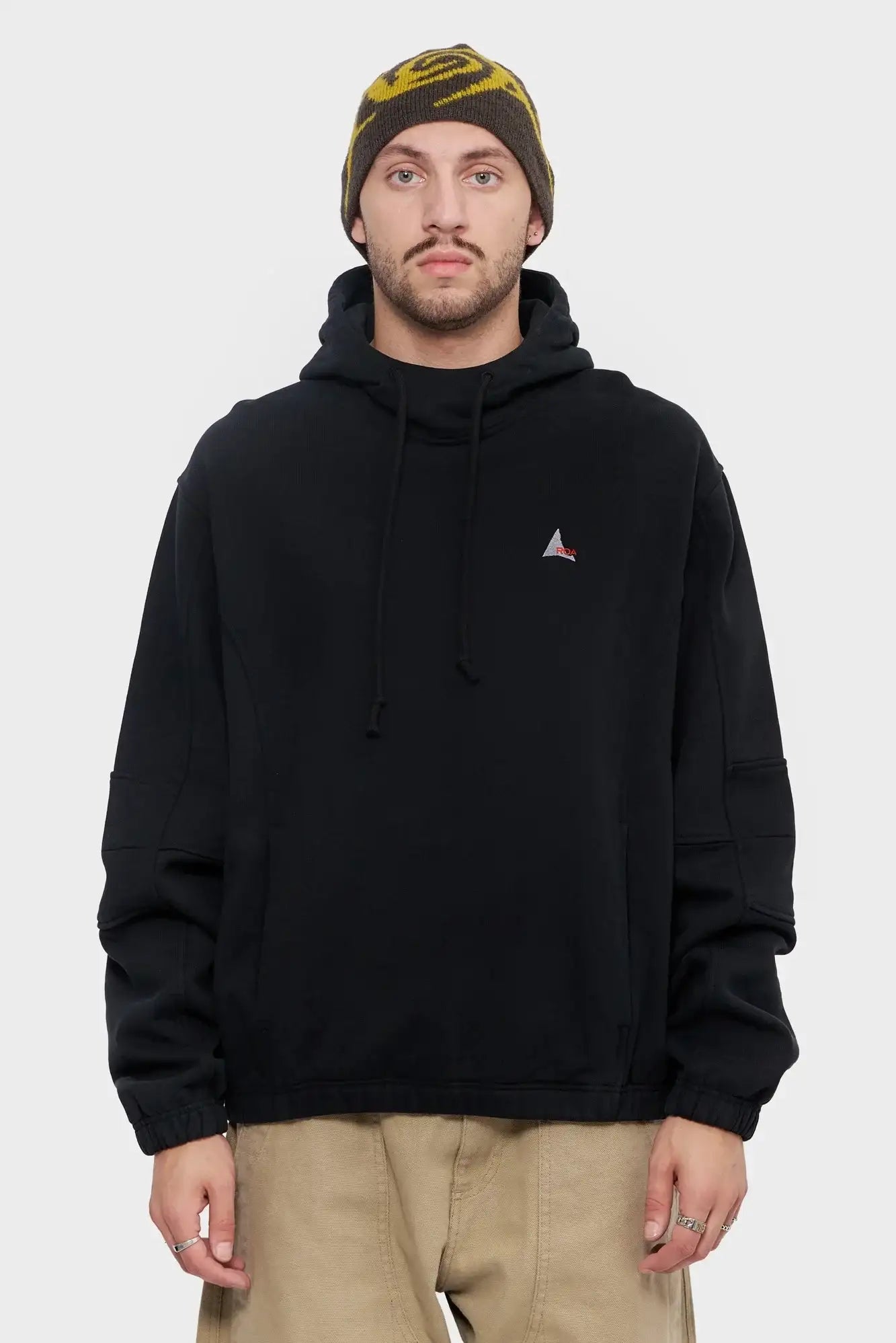 Mężczyzna w czarnej bluzie z kapturem i brązowej czapce zimowej, moda streetwear