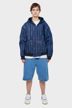 Osoba w dżinsowej bluzie z kapturem i szerokich szortach jeansowych, styl streetwear