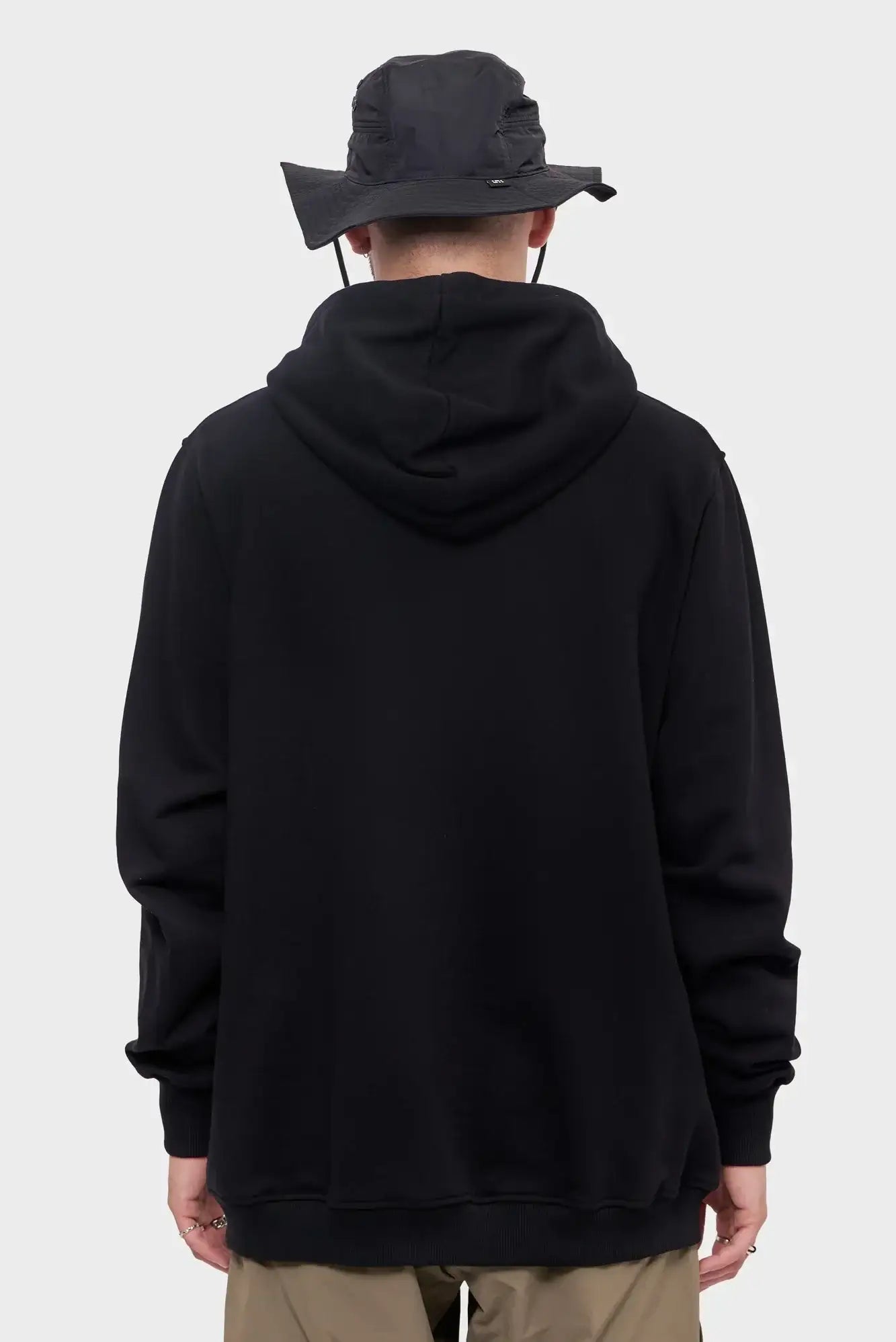 Czarna bluza z kapturem i czarny kapelusz typu bucket hat, widok od tyłu