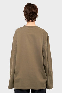 Tył oliwkowej bluzy oversize na modelu, minimalistyczny styl streetwear