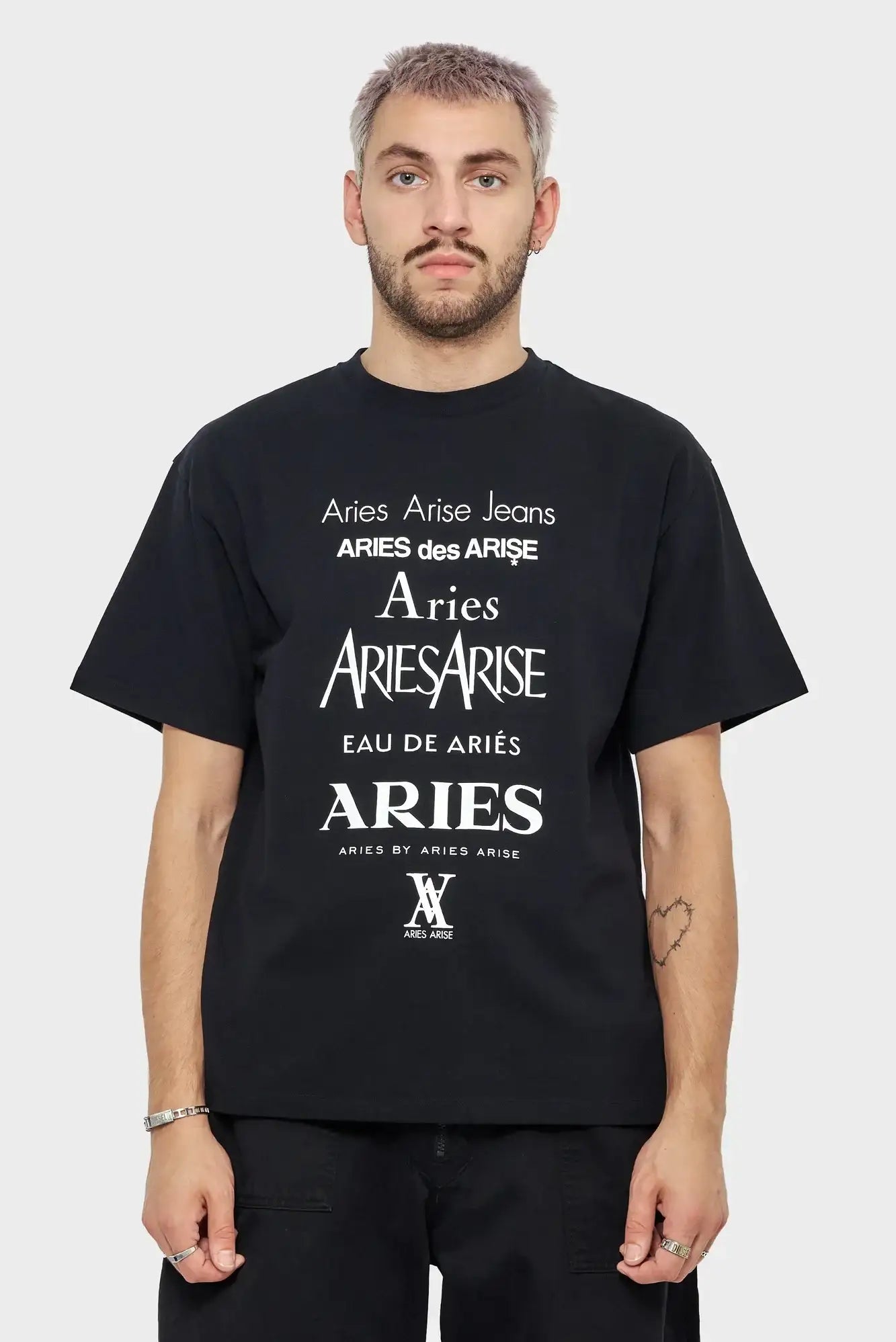 Mężczyzna w czarnej koszulce Aries z białym nadrukiem tekstowym, styl streetwear