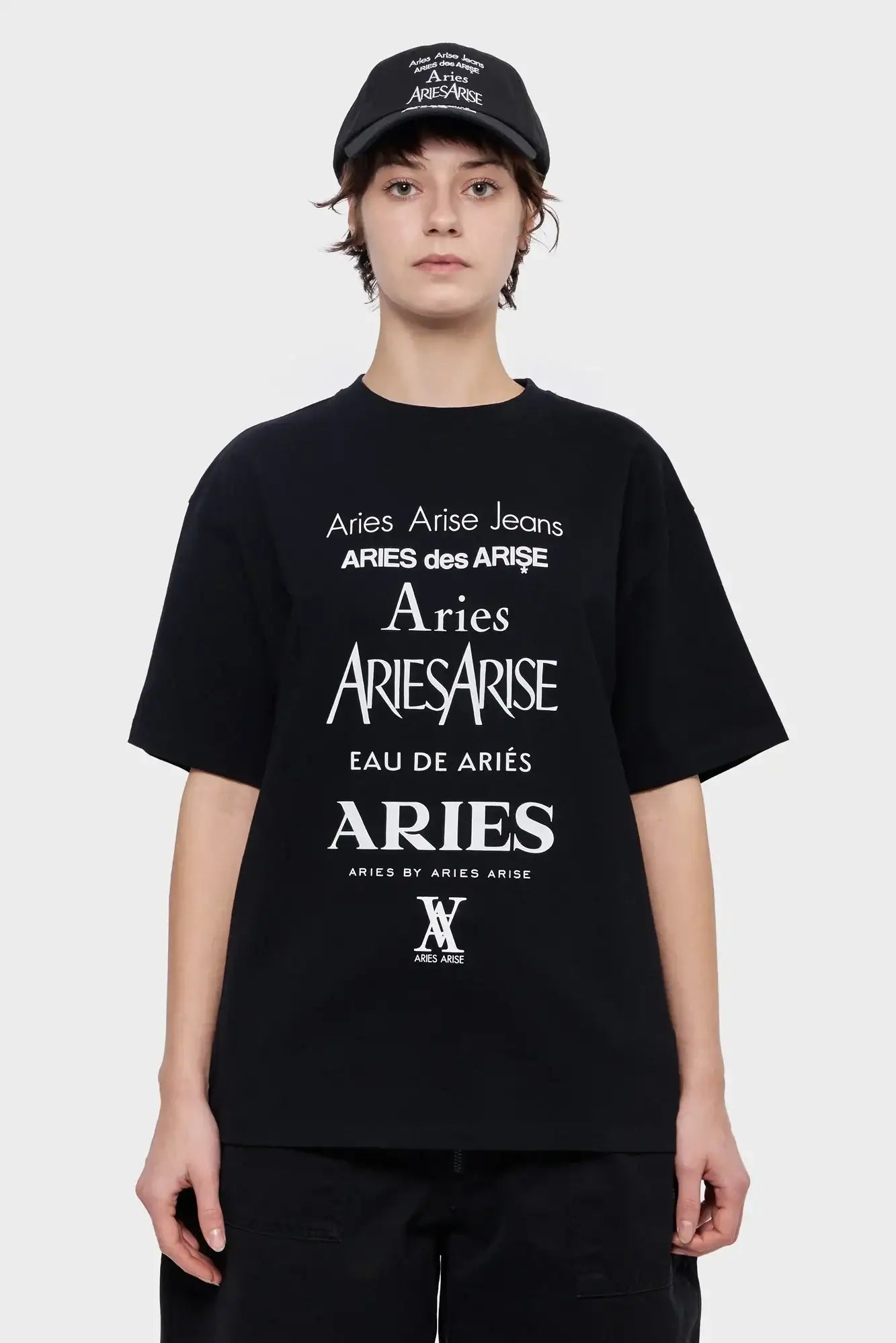 Osoba w czarnej koszulce i czapce z białym nadrukiem Aries, moda streetwear unisex