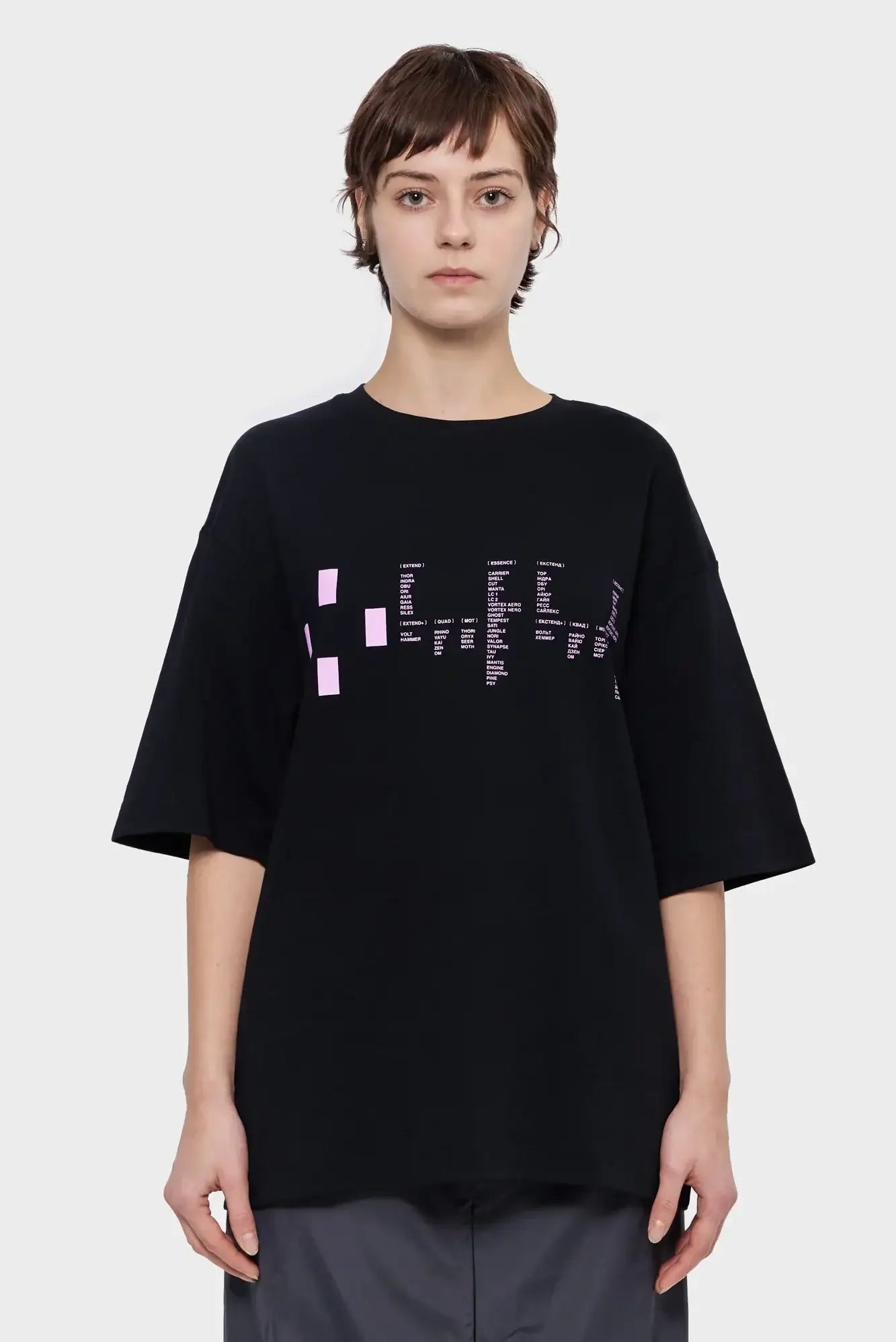 Kobieta w czarnej oversize koszulce z różowym nadrukiem, moda streetwear