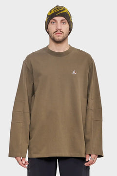 Mężczyzna w oliwkowej bluzie oversize z małym logo i wełnianej czapce, styl streetwear