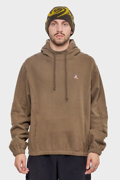 Mężczyzna w brązowej bluzie z kapturem i beżowo-żółtej czapce, moda streetwear