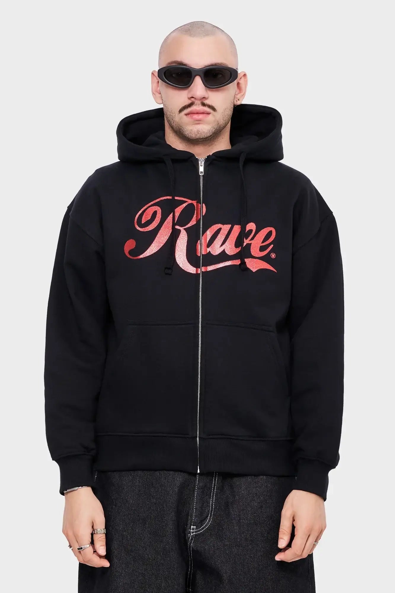 Model w czarnej rozpinanej bluzie z kapturem i napisem Rave, modne okulary, styl streetwear