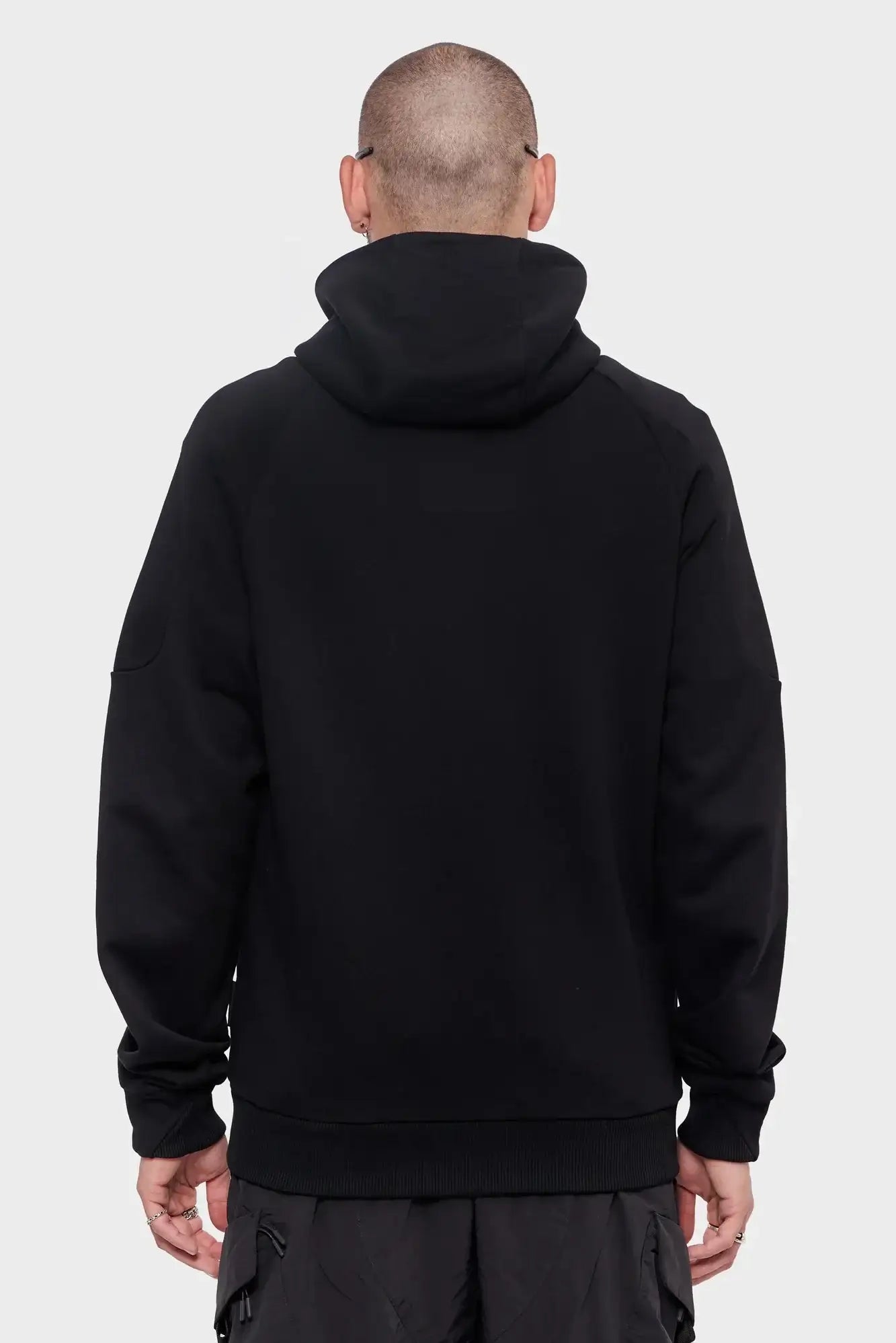 Mężczyzna w czarnej bluzie z kapturem, widok od tyłu, styl streetwear