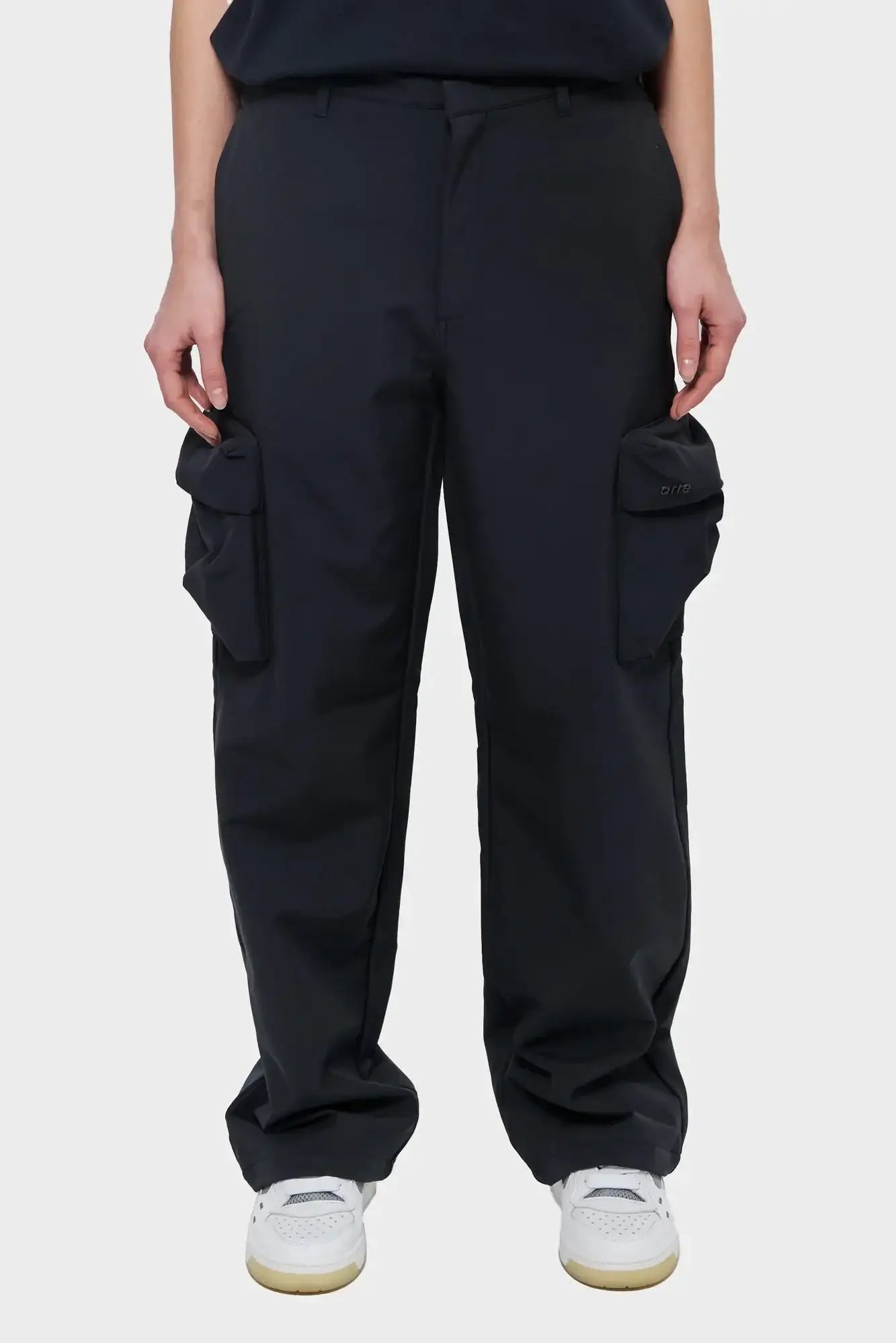 Czarne spodnie cargo z dużymi kieszeniami, prosty krój, na modelu, styl streetwear