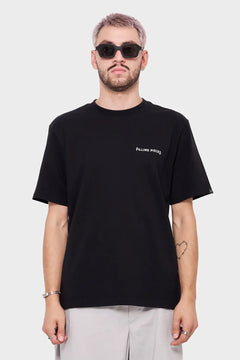 Mężczyzna w czarnej koszulce z napisem Filling Pieces, okulary przeciwsłoneczne, moda streetwear
