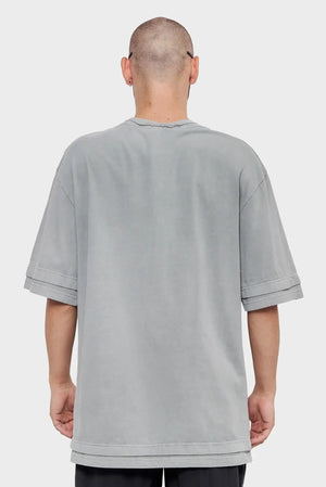 Mężczyzna w oversize szarej koszulce z krótkim rękawem, widok od tyłu, moda streetwear