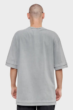 Mężczyzna w oversize szarej koszulce z krótkim rękawem, widok od tyłu, moda streetwear