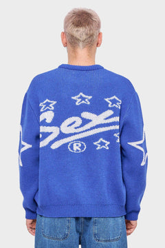 Mężczyzna w niebieskim swetrze z białym napisem i gwiazdkami na plecach, modna odzież streetwear
