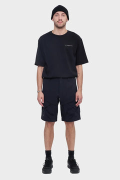 Mężczyzna w czarnej koszulce, szortach cargo i czapce beanie, styl streetwear