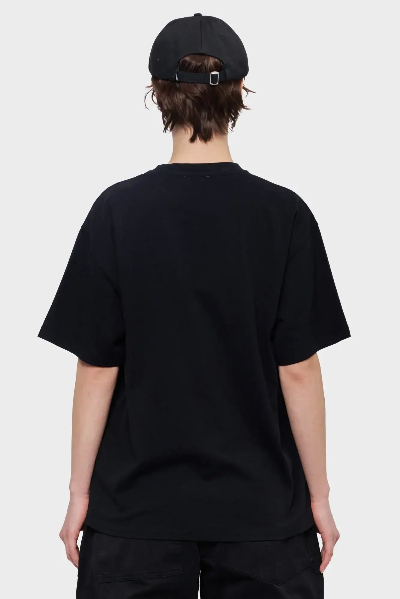 Osoba w czarnej koszulce i czapce z daszkiem, widok od tyłu, styl streetwear
