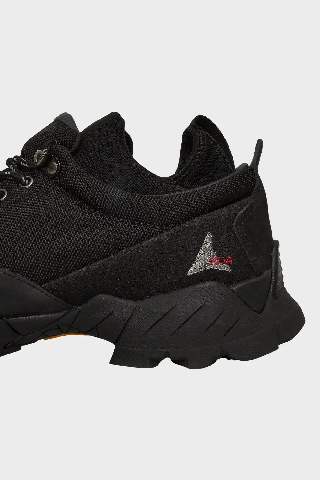 Czarny sneaker z siateczki i zamszu z logo ROA, styl streetwear, widok z boku