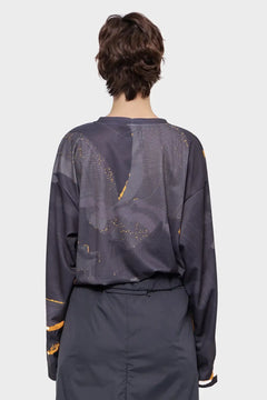 Osoba w ciemnej bluzie z abstrakcyjnym wzorem, widok od tyłu, moda streetwear