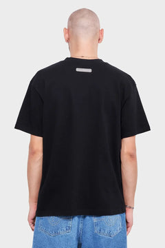Czarna koszulka z logo na plecach, krótkie rękawy, męska moda streetwear, denimowe jeansy.